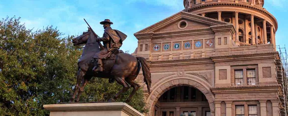Texas Capitol building with statue of man on horse in foreground